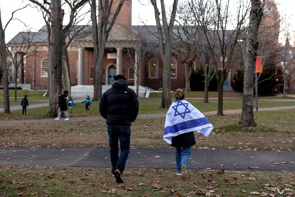 Harvard Yard campus student holding Israeli flag